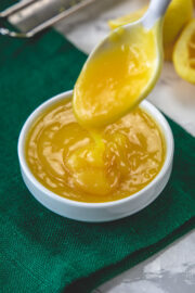 Drizzling a spoonful of dressing back into the bowl to show thick texture.