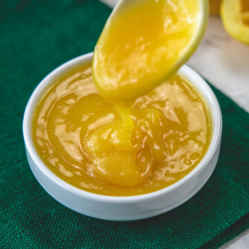Drizzling a spoonful of dressing back into the bowl to show thick texture.