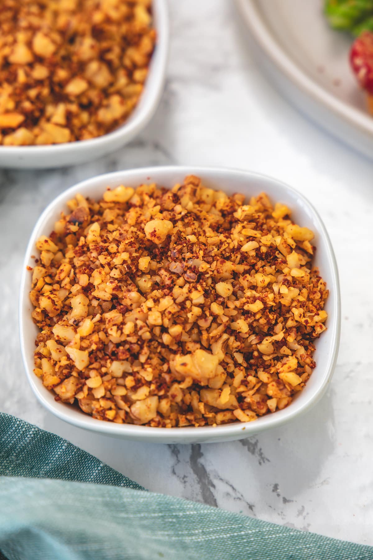 Close up of walnut meat in a white bowl.