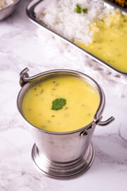 Gujarati kadhi in a balti serving dish with a garnish of cilantro leaf.