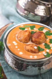 Malai kofta garnished with cilantro leaves.