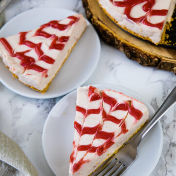 2 sliced of strawberry cheesecake served in plate and remaining on back side.