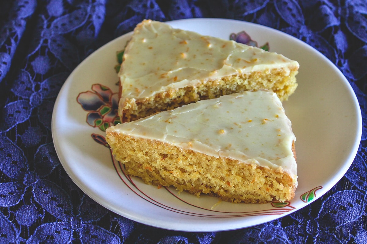 2 slices of orange cake on the plate.  Eggless Orange Cake Recipe with orange ici Eggless orange cake 4