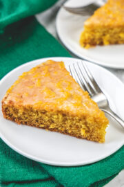 A slice of orange cake in a plate with fork.