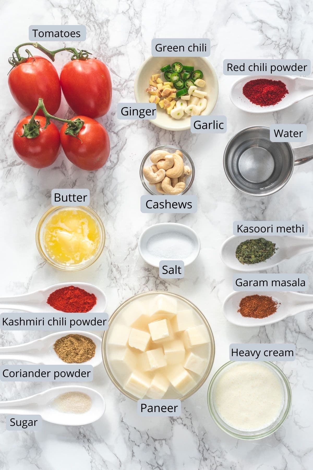 Ingredients used in paneer makhani recipe in individual bowls and spoons.