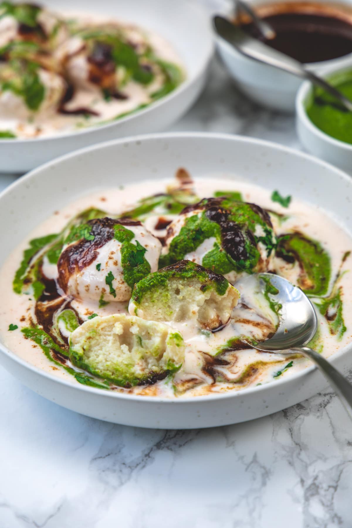 Dahi vada cut into half to show the texture.