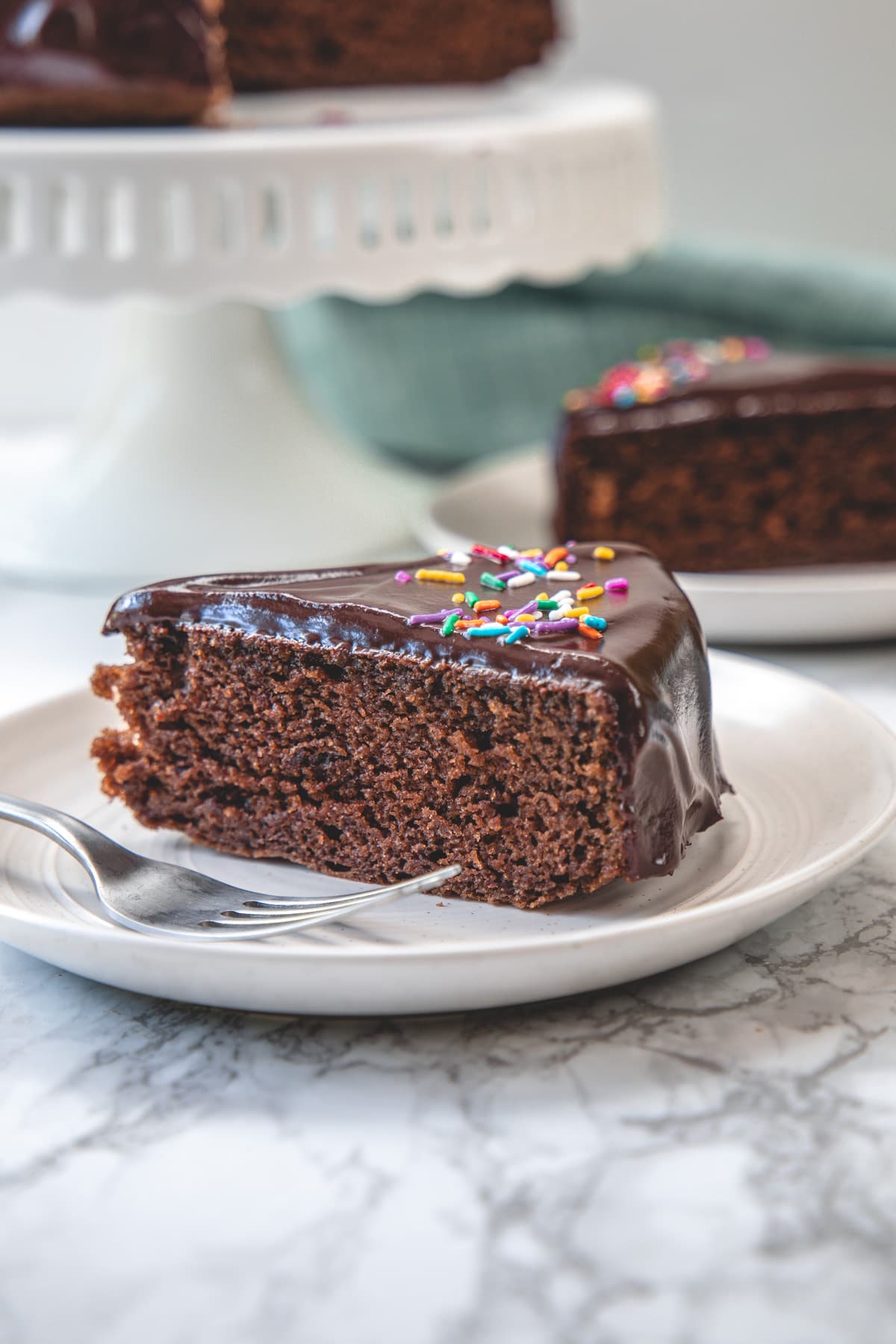 a slice of eggless chocolate cake in a plate with fork.