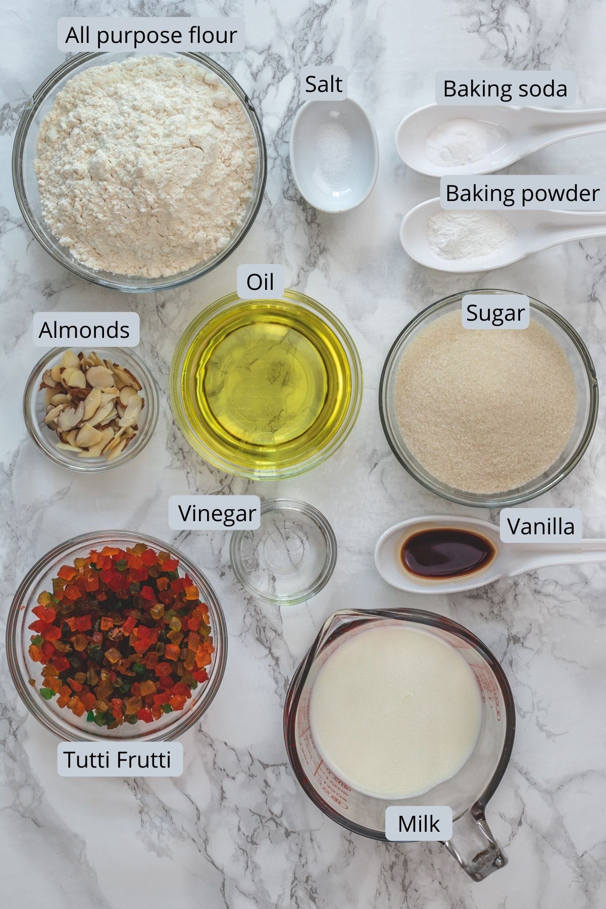 Eggless tutti frutti cake ingredients in individual bowls.