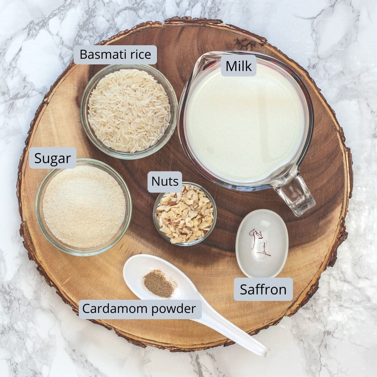 kheer ingredients in individual bowls on a wooden board.