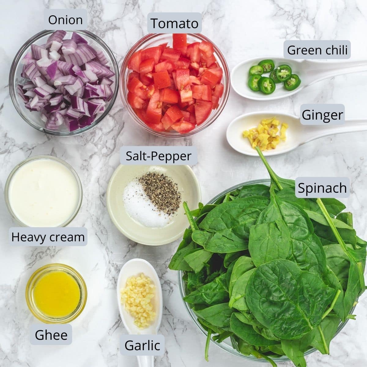 Ingredients used in spinach soup are in individual bowls and spoons.
