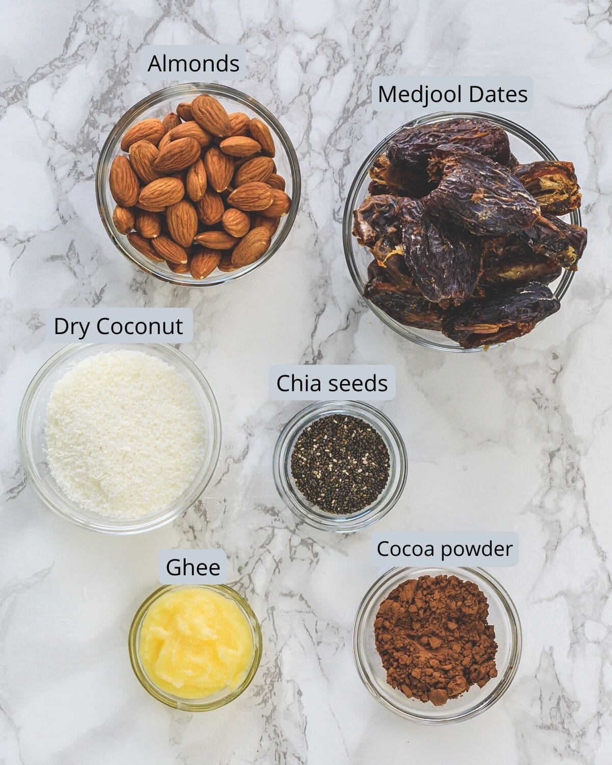 Ingredients used in making date energy balls are in individual bowls.
