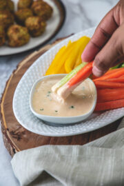 Dipping carrot and cucumber in tahini sauce.