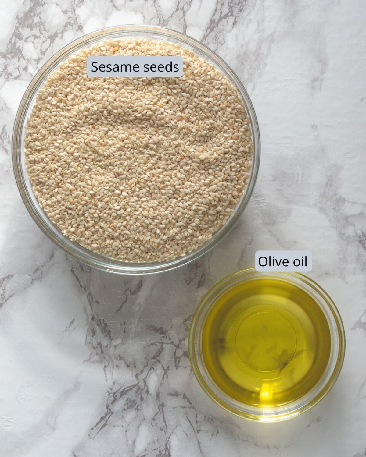 Sesame seeds and olive oil in individual bowls.