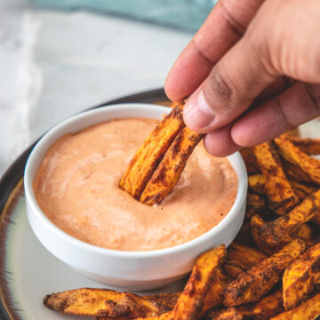 Dipping sweet potato fries into the fry sauce.