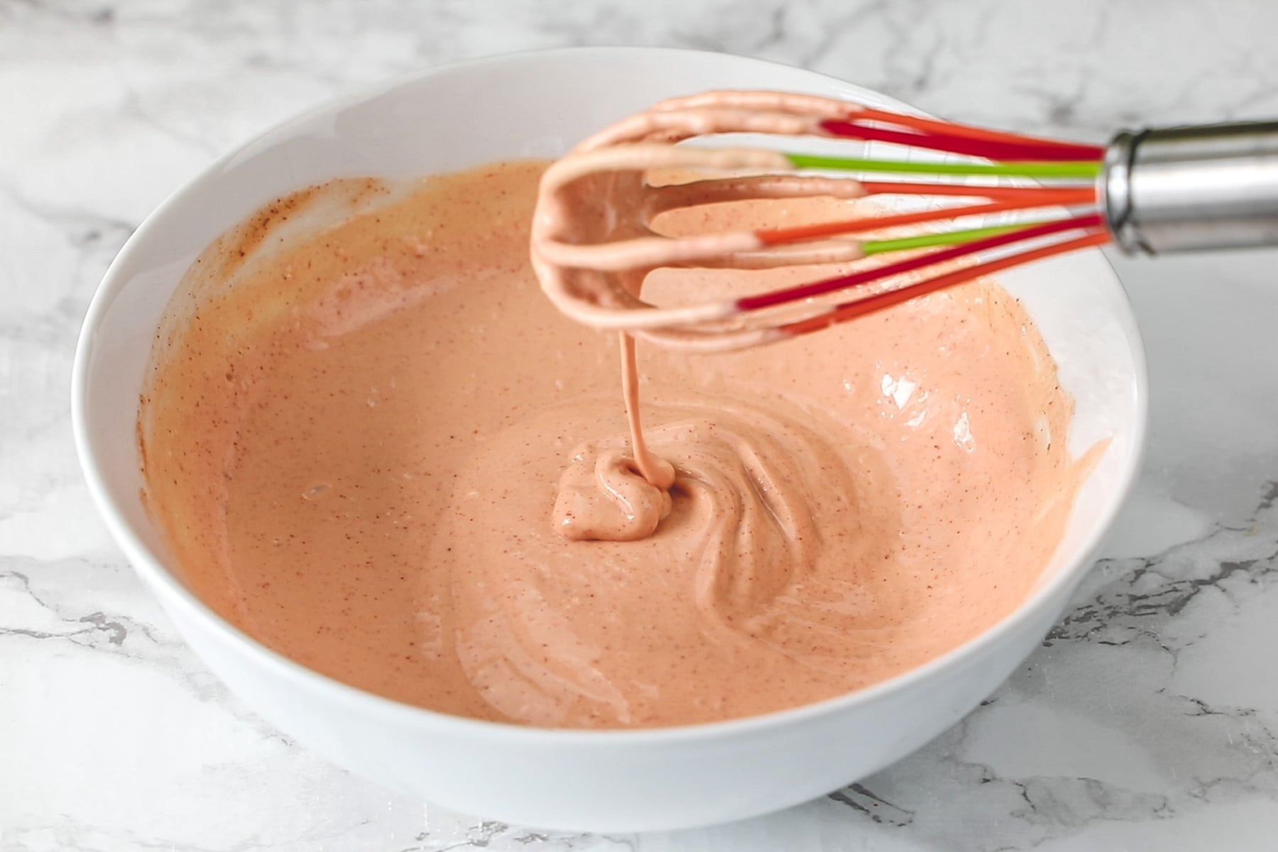 Showing the consistency of fry sauce using whisk.