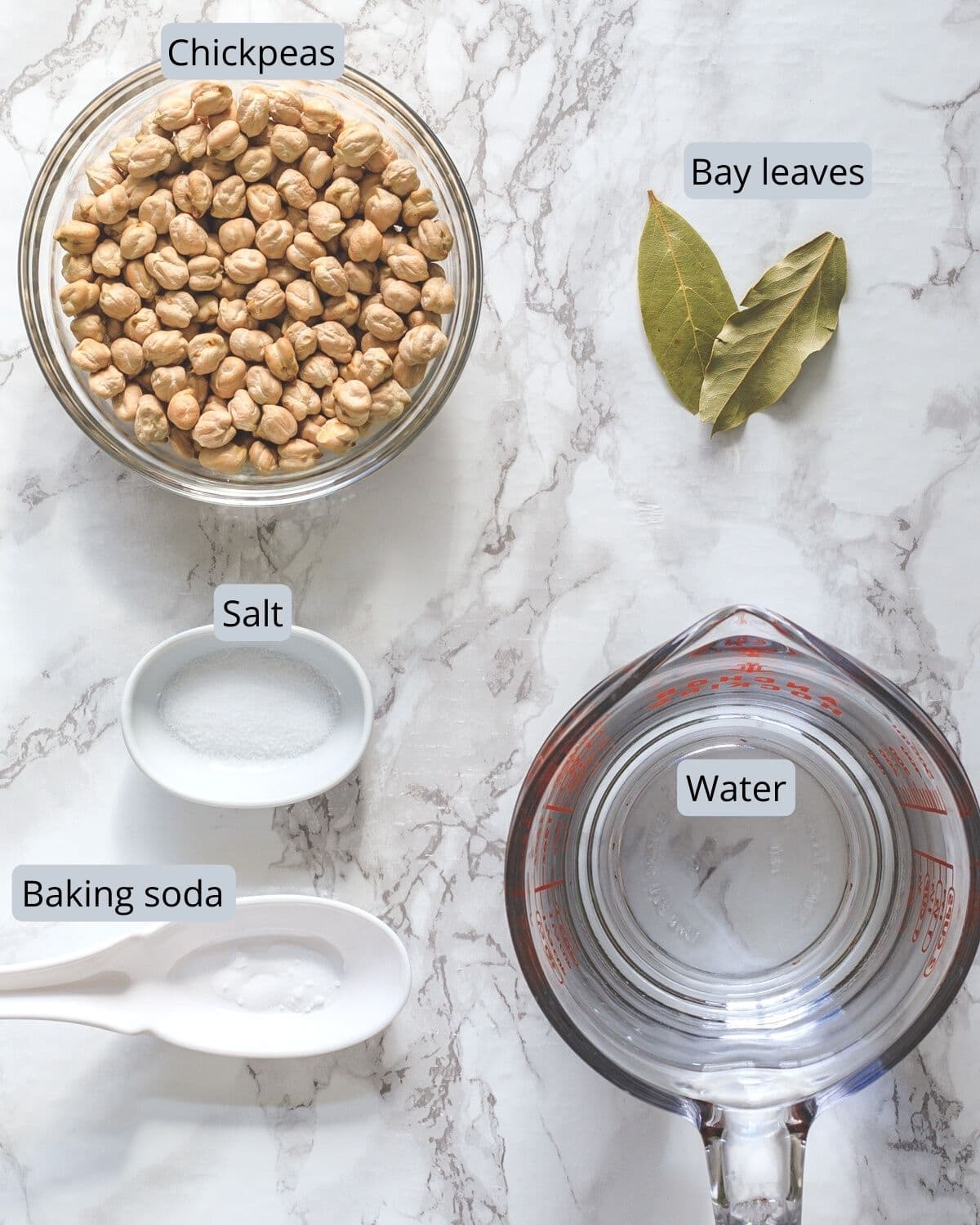 Ingredients used for cooking chickpeas in instant pot in individual bowls and spoons.