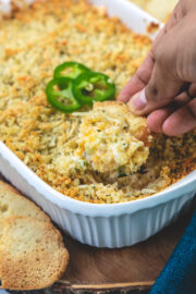 Scooping jalapeno popper dip using crostini.