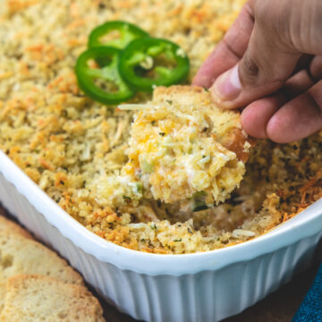 Scooping jalapeno popper dip using crostini.