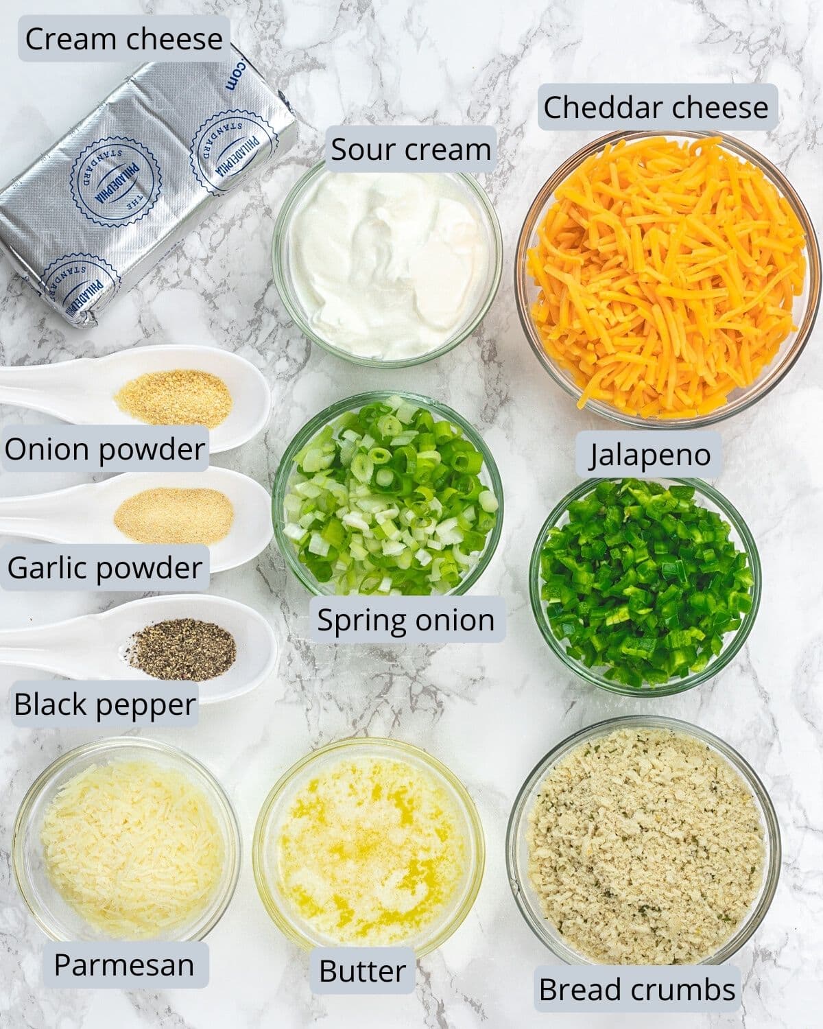 Ingredients used in jalapeno popper dip in indivial bowls and spoons.