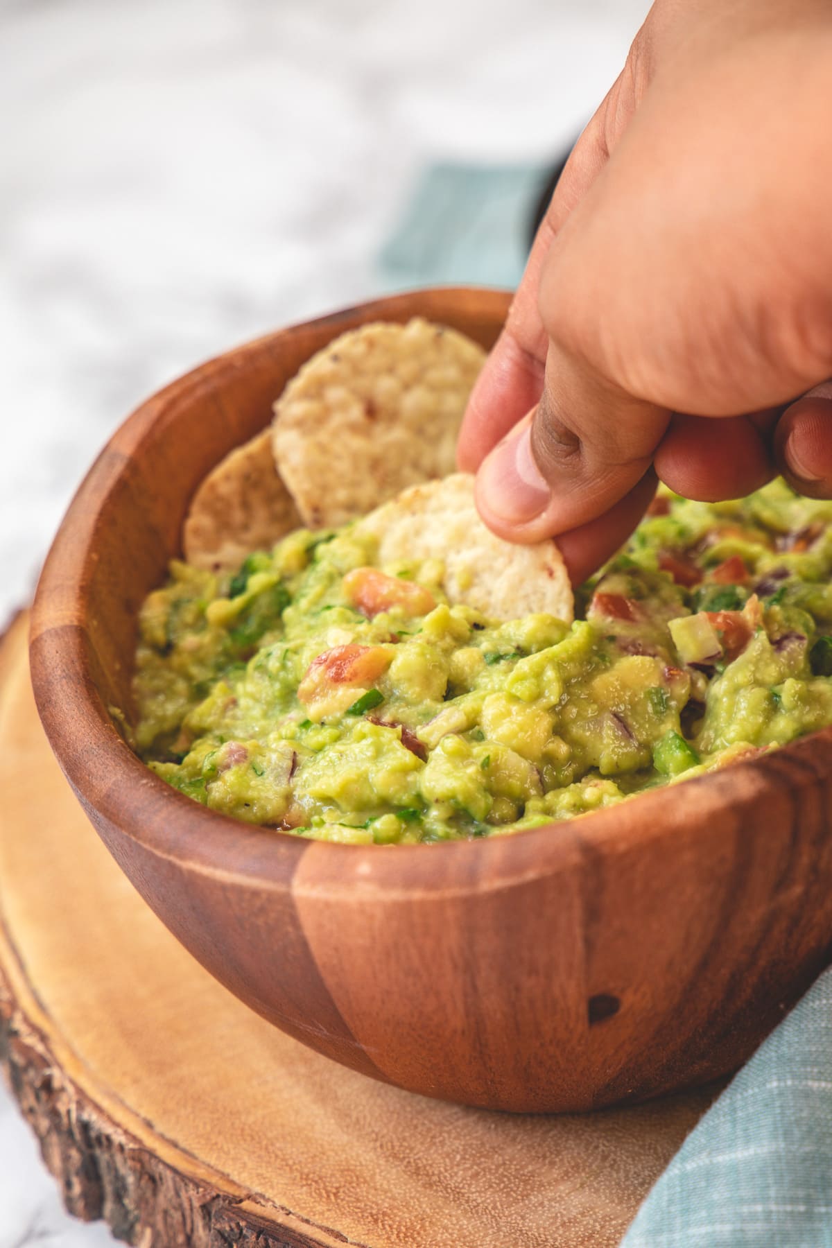 Scooping spicy guacamole with a tortilla chip.