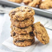 A stack of eggless oatmeal cookies on a piece of parchment paper.