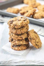 A stack of eggless oatmeal cookies on a piece of parchment paper.