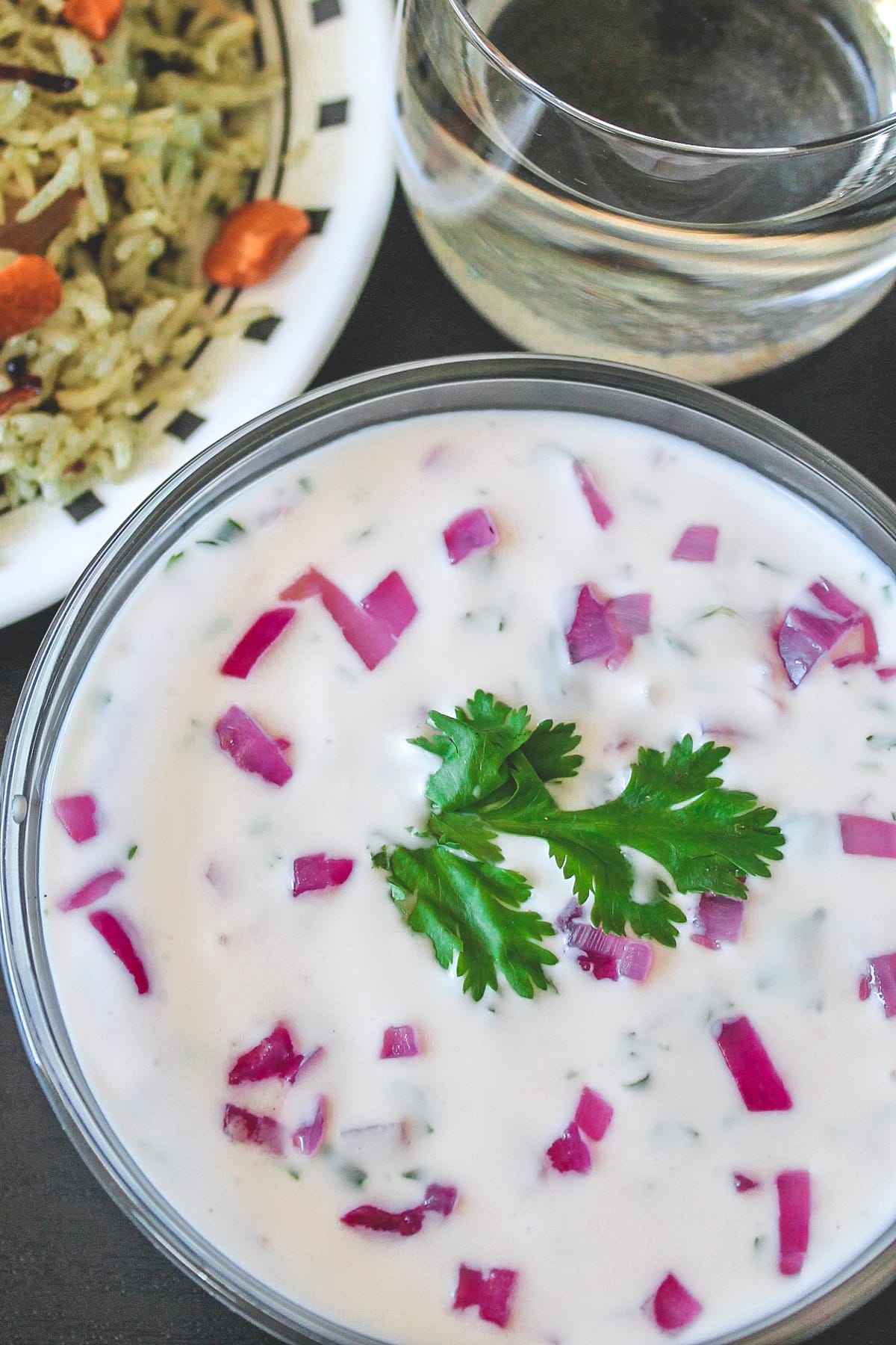 Onion raita served with rice and a glass of water.