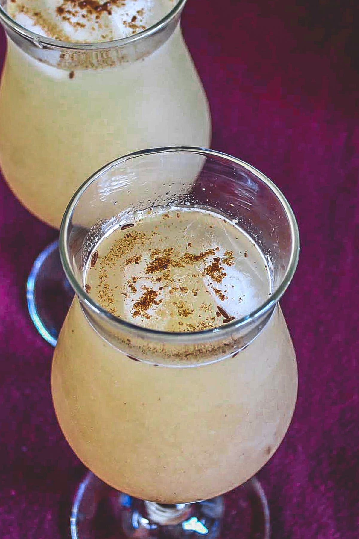 2 glass of aam panna garnished with roasted cumin powder.