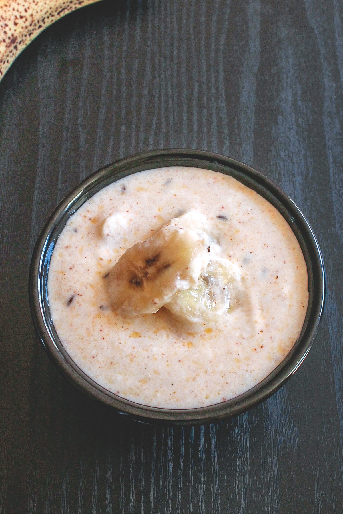 Banana raita served in a black bowl.