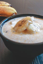 Banana raita served in a bowl with few banana slices on top.