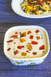 Capsicum raita served with biryani in the back.