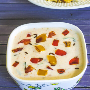 Capsicum raita served with biryani in the back.