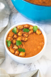 chickpea tikka masala in a bowl garnished with cilantro and napkin on the side.