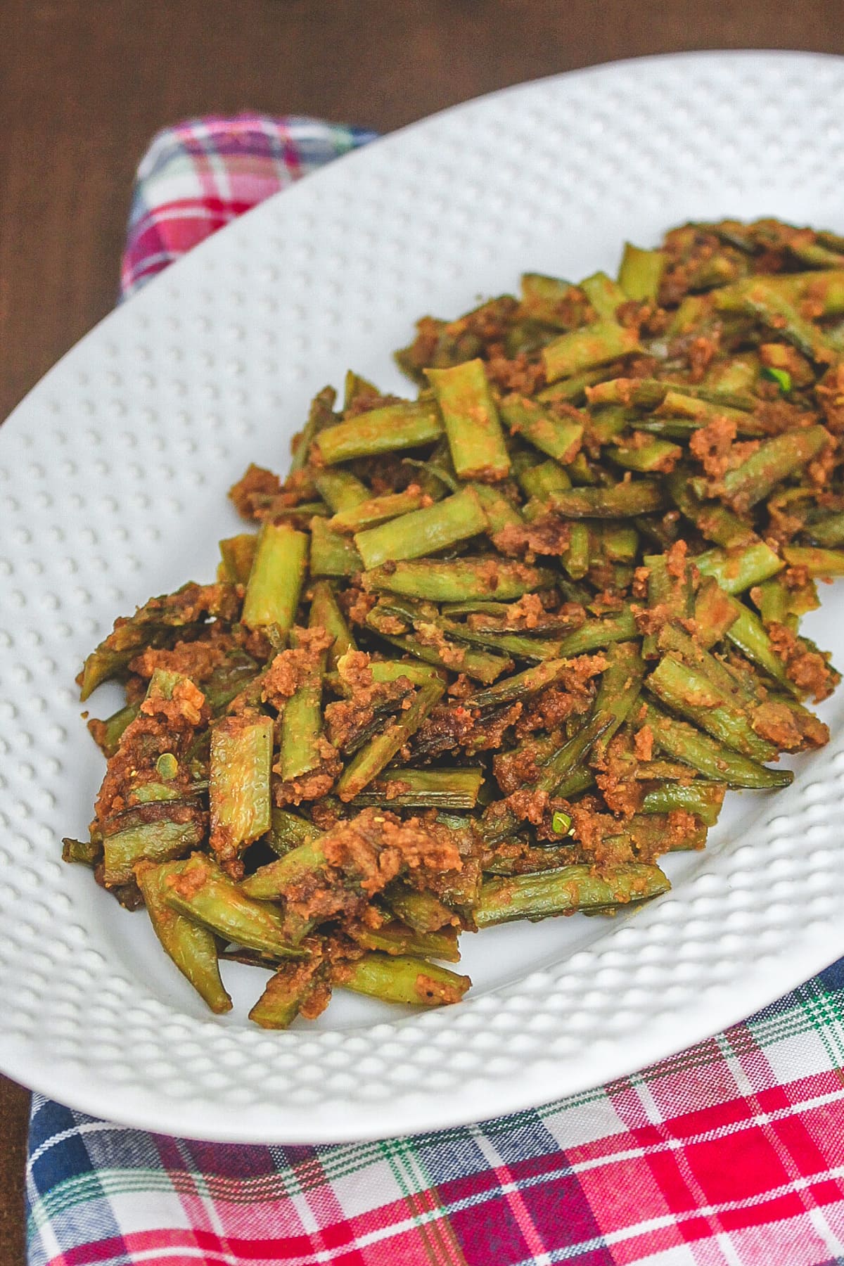 Cluster beans recipe in a white oval plate with napkin underneath.