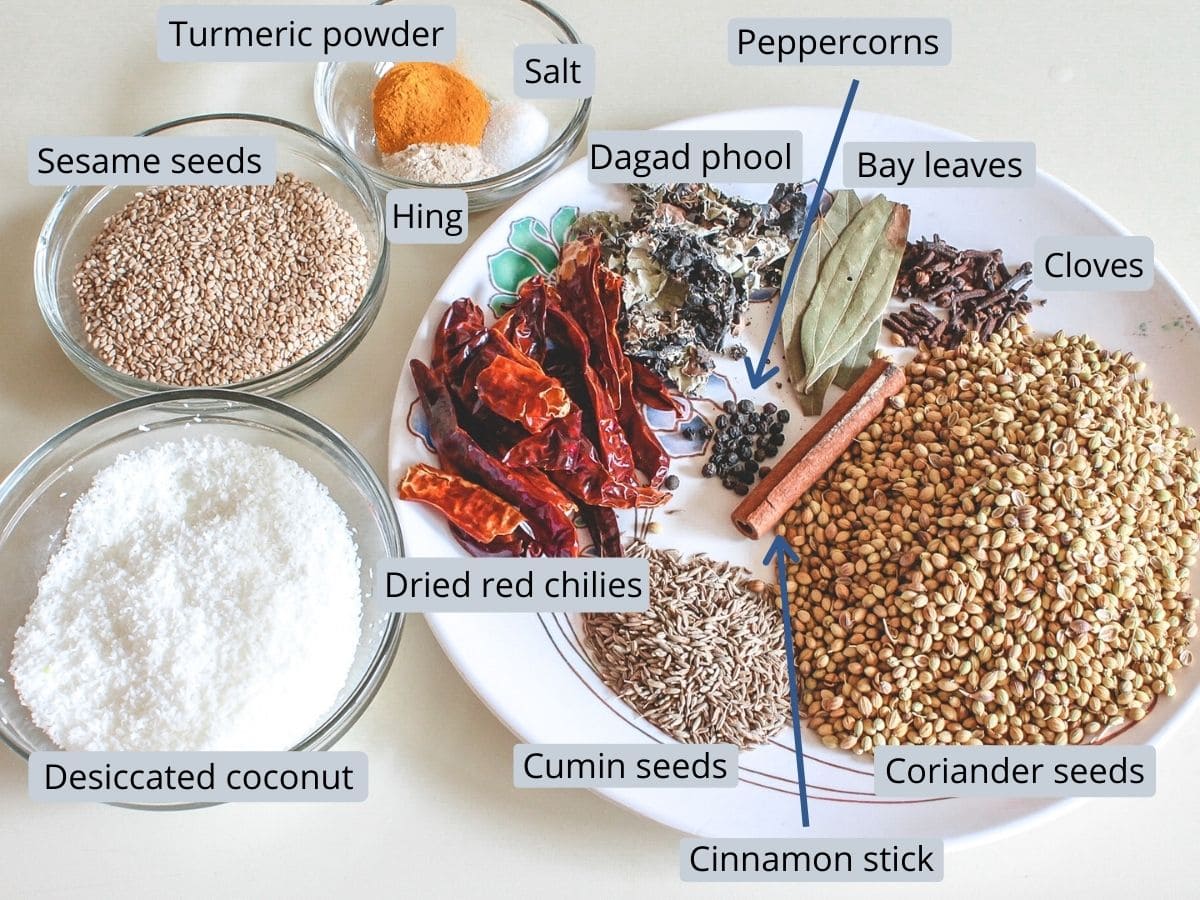 Spices used for goda masala with labels in a plate and bowls.