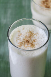 Sweet lassi garnished with cardamom powder.