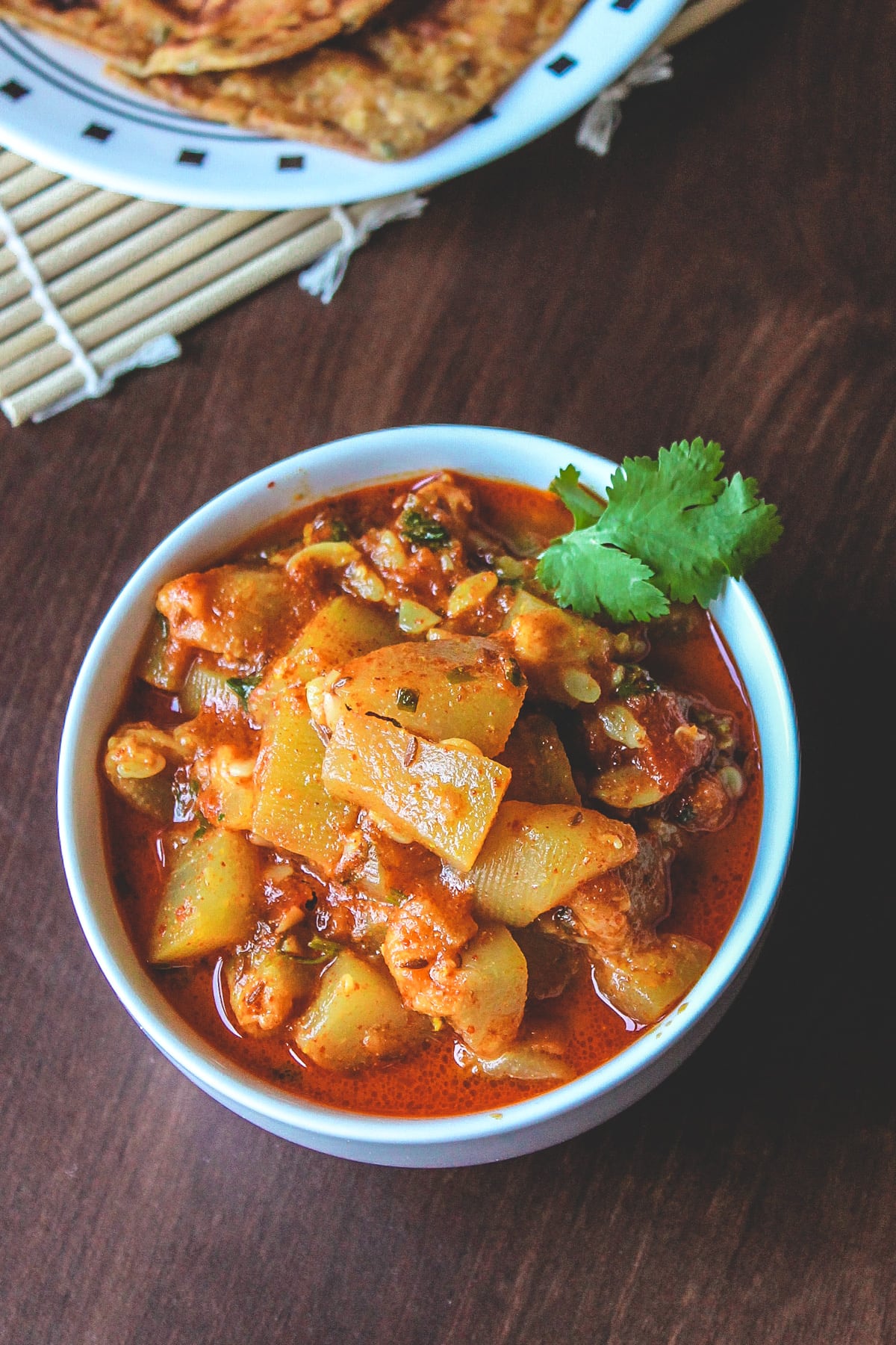 Lauki tamatar sabzi in a bowl, garnished with cilantro.