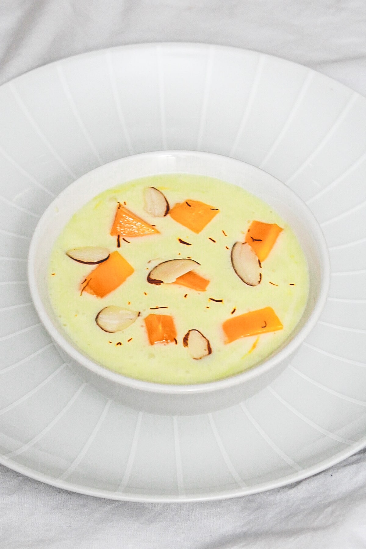 mango raita garnished with mango cubes, almonds and saffron.