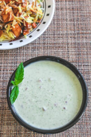 Mint raita garnished with mint leaves and served with biryani.