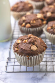 Close up of mocha muffin on the cooling rack with milk bottle and more muffins in the back.