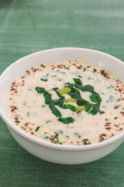 Spinach raita served in a bowl garnished with roasted cumin powder