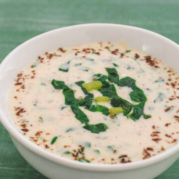 Spinach raita served in a bowl garnished with roasted cumin powder