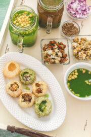Pani puri served in oval plate with all its elements served on side.