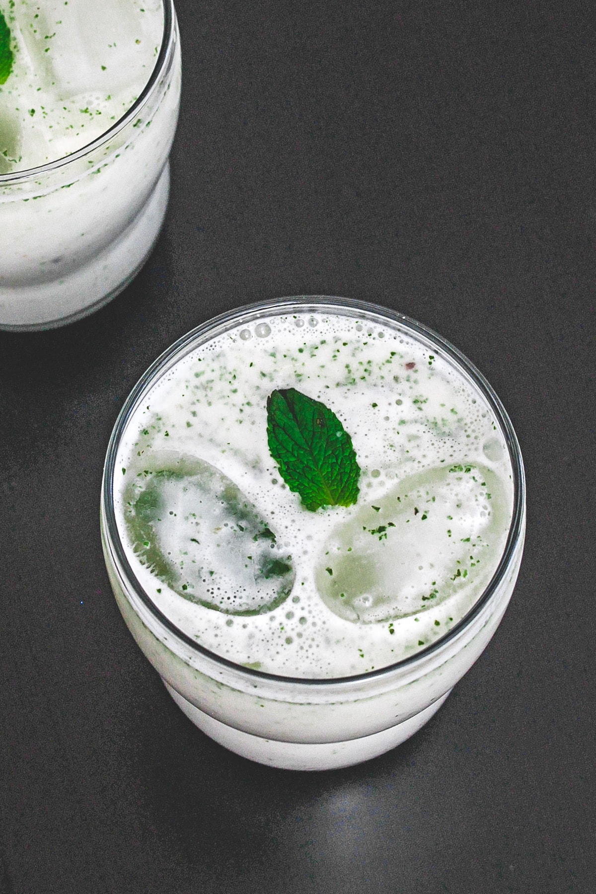 Pudian chaas with ice cubes and garnished with a mint leaf.