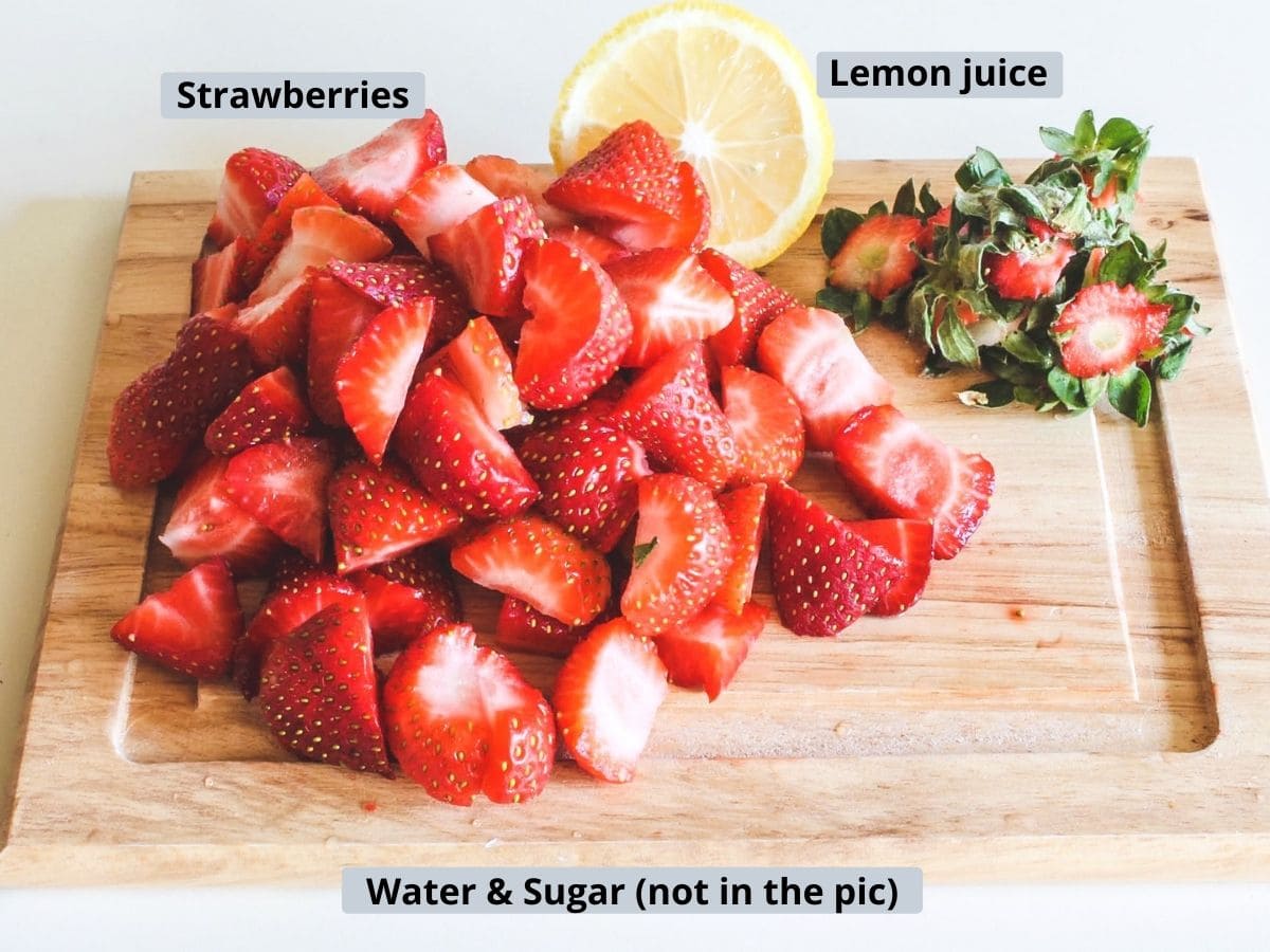 Ingredients for strawberry juice with labels on a wooden chopping board.