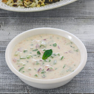 Mix veg raita garnished with mint leaf and served with biryani.