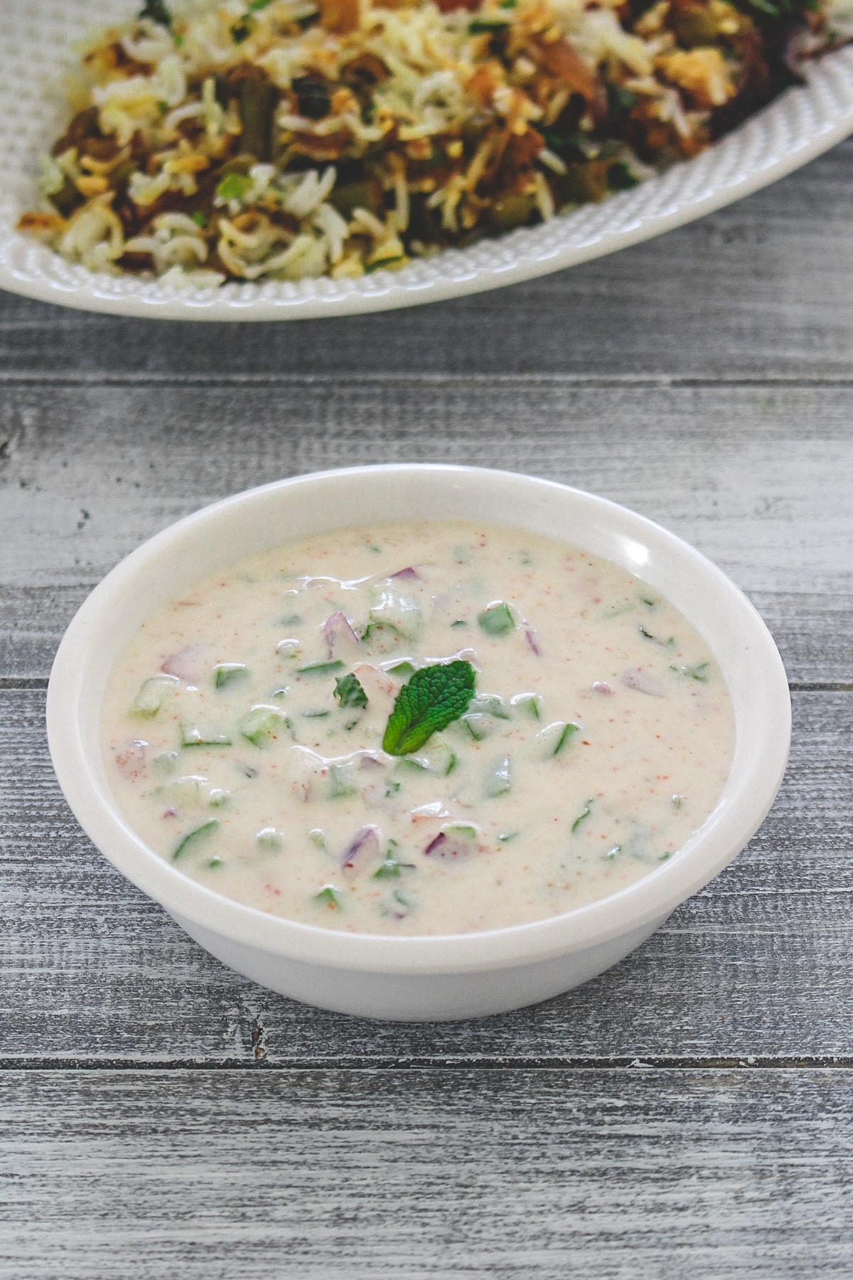 Mix veg raita garnished with mint leaf and served with biryani.