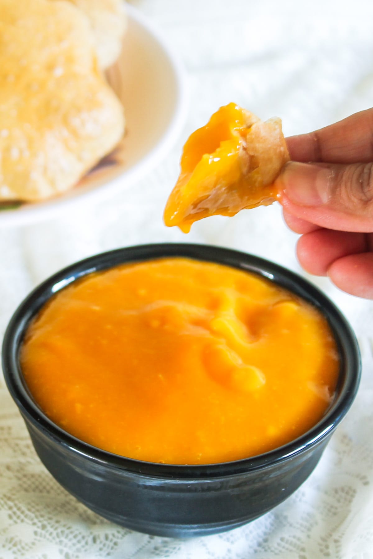 A piece of puri dipped into the aamras.