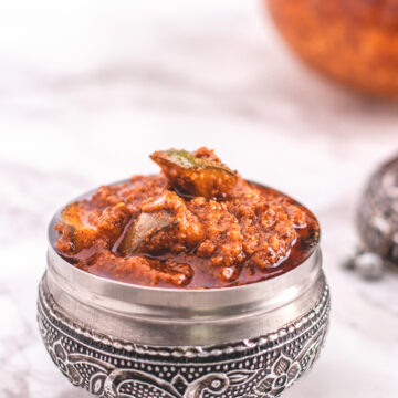 Andhra mango pickle in a steel serving bowl jar.