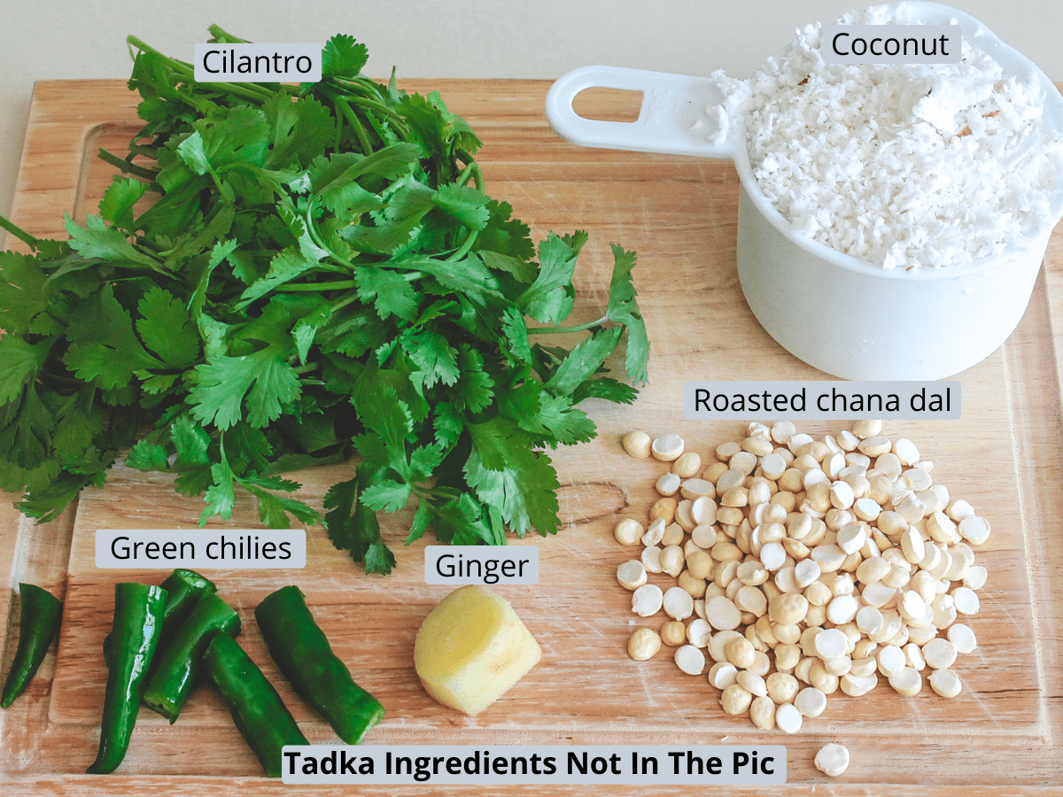 Ingredients used in coriander coconut chutney with labels on a wooden board.